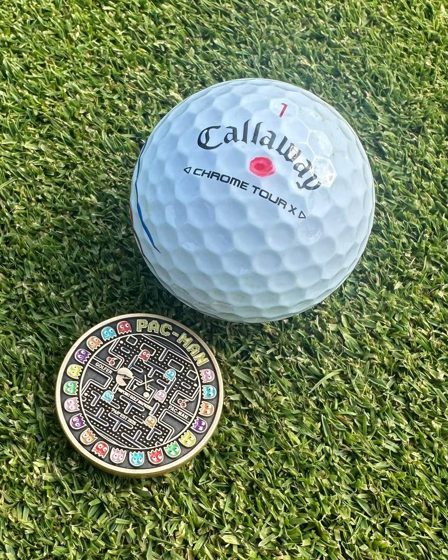 The Pac-Man marker sitting on the green next to a golf ball