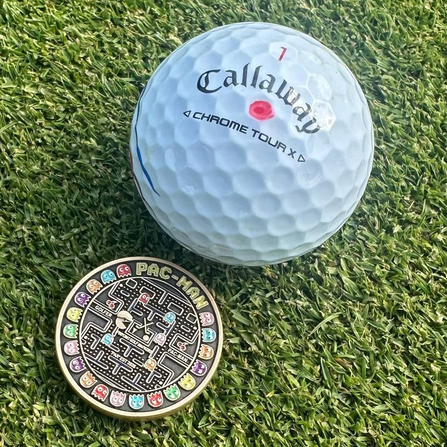 A Pac-Man marker on the green beside a golf ball